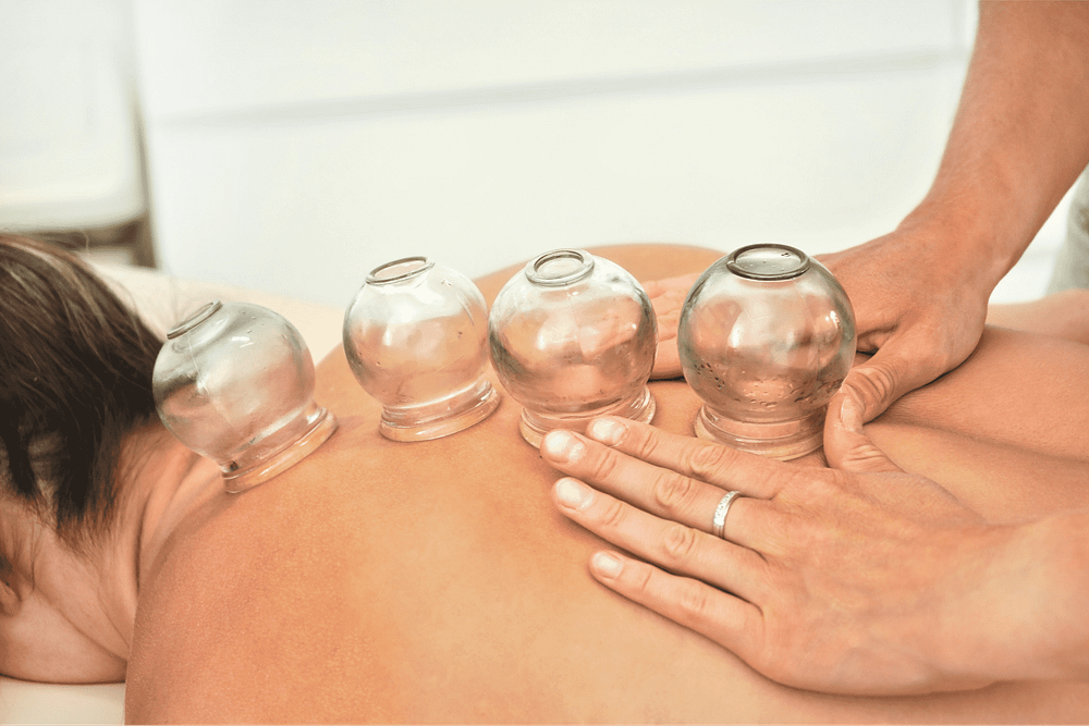 young-female-physiotherapist-applying-glass-suction-banks-back-her-patient-during-cupping-therapy-closeup-detail