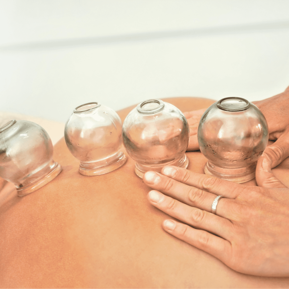 young-female-physiotherapist-applying-glass-suction-banks-back-her-patient-during-cupping-therapy-closeup-detail